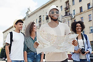 Happy hipsters using navigation map to explore the city