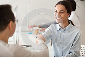 Happy hired intern or promoted woman employee smiling handshakin