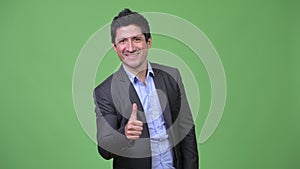 Happy Hispanic businessman giving thumbs up