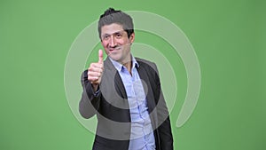 Happy Hispanic businessman giving thumbs up