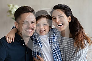 Happy hispanic couple and son smiling looking at camera