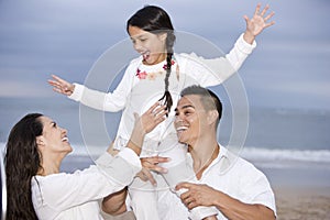 Happy Hispanic family and girl having fun on beach