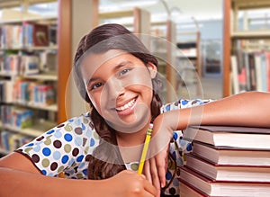 Happy Hispanic Girl Student with Pencil and Books Studying in Library