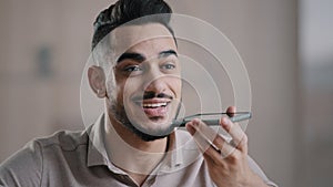 Happy hispanic man guy young assistant hold cellphone record speech audio message on mobile speakerphone use digital