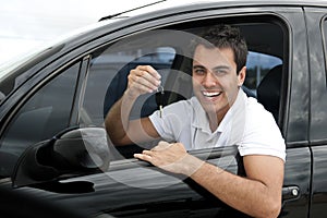 Happy hispanic man in his new car