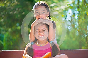 Happy hispanic sisters in summer park