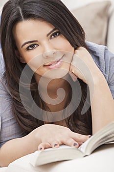 Happy Hispanic Woman Reading Paperback Book