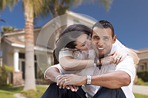 Happy Hispanic Young Couple in Front of Their New Home