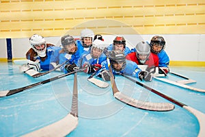 Happy hockey team laying on ice rink at stadium