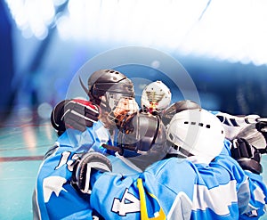 Happy hockey winners with trophy on ice rink