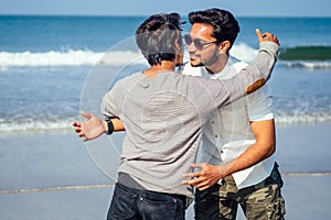 Happy holi two indian stylish mans young friends hugging on the beach by the sea.long-awaited meeting diwali of the