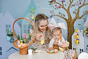 Happy holiday. Mother and her daughter with painting eggs.