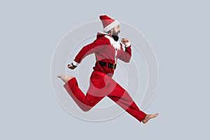 Happy holiday. santa ctlaus in hat hurry up to xmas shopping sales. running bearded man in christmas costume. concept of