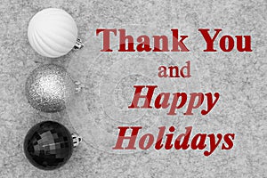 Happy Holidays greeting with black and white ball ornaments on gray felt