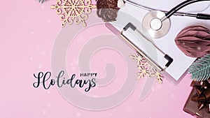 Happy Holidays moving text with stethoscope and Christmas decorations with snow. Medical greeting Xmas background