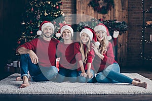 Happy holidays.Photo of dad mom sister brother spending x-mas eve together sitting floor near garland tree indoors wear