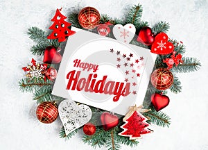 Happy Holidays Text with Holiday Evergreen Branches and photoframe New Year tree, red decorations Top view, flat lay