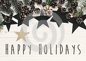 Happy Holidays text on modern christmas flat lay with green fir