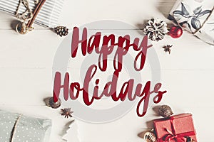 Happy holidays text, seasonal greetings card sign. christmas fla