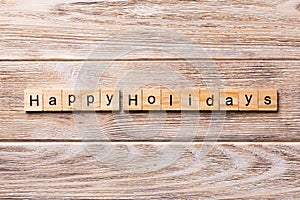 Happy Holidays word written on wood block. Happy Holidays text on wooden table for your desing, concept