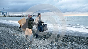 Happy homeless couple, a man and a woman running on the beach