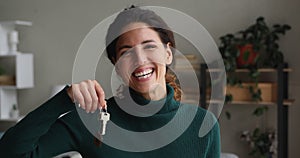 Happy homeowner woman smiling showing bunch of keys into camera