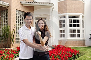 Happy homeowners infront of new house photo