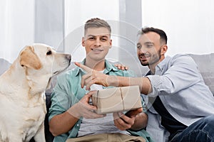 happy homosexual man holding valentines present