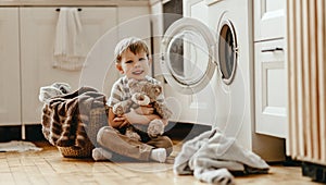 Happy  householder child boy in laundry   with washing machine