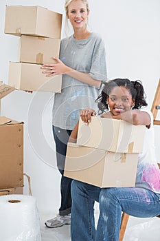 Happy housemates carrying cardboard moving boxes