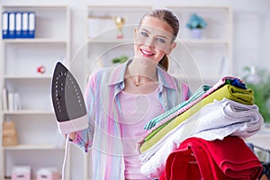 The happy housewife doing ironing at home