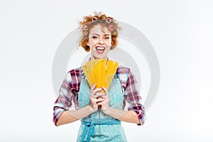 Happy housewife standing and holding uncooked spagetti