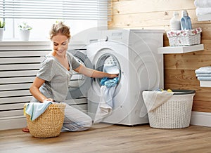 Happy housewife woman in laundry room with washing machine