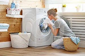 Happy housewife woman in laundry room with washing machine