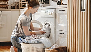 Happy housewife woman in laundry room with washing machine