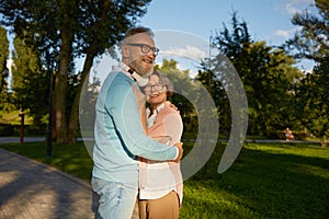 Happy hugging with love senior couple outdoors over public green park