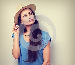 Happy humorous grimacing woman in summer hat thinking about vacation and looking. Vintage toned portrait