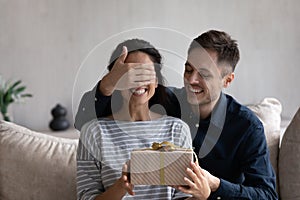 Happy husband giving surprise gift to excited wife