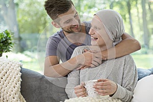 Happy husband hugging his wife recovering from chemotherapy for photo