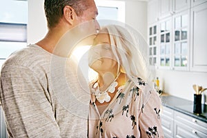 Happy husband hugging wife at kitchen counter