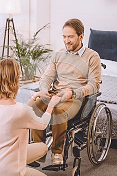 happy husband on wheelchair and wife