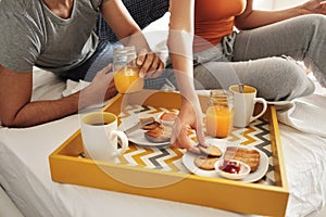 Happy Husband And Wife Eating Breakfast In Bed