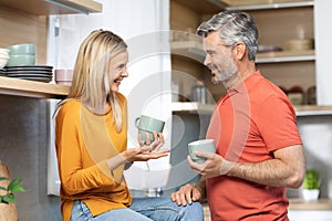 Happy husband and wife enjoying morning coffee at home