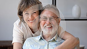 Happy husband and wife looking at camera with toothy smiles