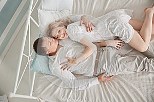 Happy husband and wife lying on the bed