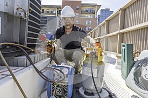 Happy HVAC technician recovering refrigerant photo