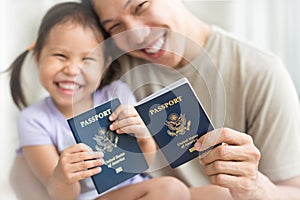 Happy immigrant family becoming new American citizens, holding US passports