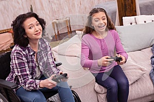 Happy incapacitated woman and girl playing games