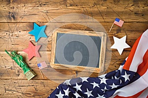 Happy Independence Day, 4th of July celebration concept with chalkboard frame and USA flag on wooden background. Top view from