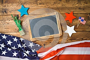 Happy Independence Day, 4th of July celebration concept with chalkboard frame and USA flag on wooden background. Top view from